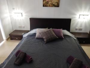 - une chambre avec un grand lit et des oreillers dans l'établissement Duplex penthouse with swimming pool, à Xgħajra