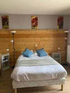 a bedroom with a large bed with two blue pillows at Auberge de France in Kruth