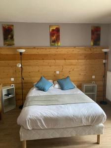 1 dormitorio con 1 cama grande y 2 almohadas azules en Auberge de France, en Kruth
