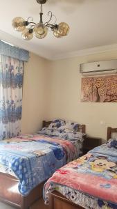 a bedroom with two beds and a chandelier at Stanley Bridge apartment Alexandria in Alexandria