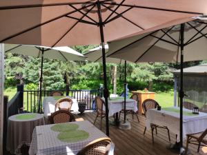 una terraza con mesas, sillas y sombrillas en La Tremblante, en Mont-Tremblant