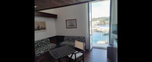 a room with a couch and a table and a balcony at Al Mari Suites in Ponza