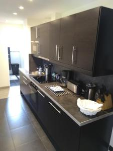 a kitchen with black cabinets and a counter top at L'échappée belle in Touques