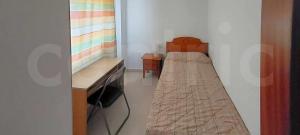 um pequeno quarto com uma cama e uma secretária em Piso en zona teatinos by Centric em Málaga