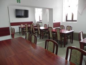 une salle à manger avec des tables et des chaises en bois dans l'établissement Dom Wczasowy Magnolia, à Lądek-Zdrój