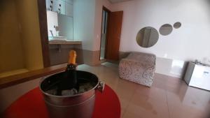 a bottle of wine in a bucket in a kitchen at MOTEL HORA EXTRA in Jataí