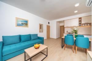 a living room with a blue couch and a table at Apartments Bonazza in Petrovac na Moru