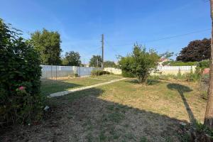 a backyard with a fence and a yard with trees at Elma Stay Location LEstran in Marennes