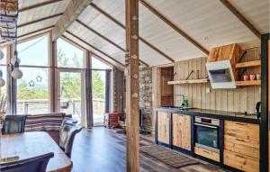 uma cozinha com paredes de madeira e uma grande janela em Stunning Home In Evje With Kitchen em Evje