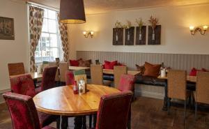 une salle à manger avec des tables et des chaises dans un restaurant dans l'établissement Lamb Hotel by Greene King Inns, à Ely