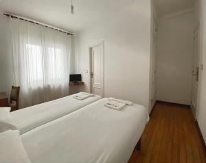 A bed or beds in a room at Pensión Residencia J. Lago