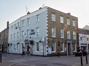 a large white building on the corner of a street at Lamb Hotel by Greene King Inns in Ely
