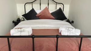 a bed with a black frame and pillows on it at Chapel row 4 in Wirksworth