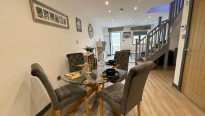 a dining room with a glass table and chairs at Chapel Row Cottages 4 in Wirksworth