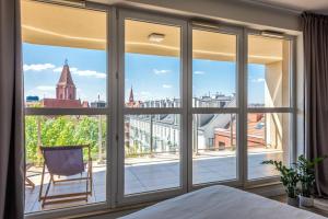 1 dormitorio con ventana grande con vistas a la ciudad en apartamenty-wroc Old Town Residence, en Wroclaw