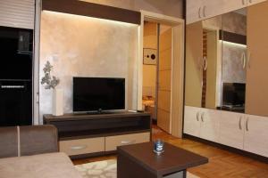 a living room with a flat screen tv on a cabinet at Perla Lux in Vrnjačka Banja