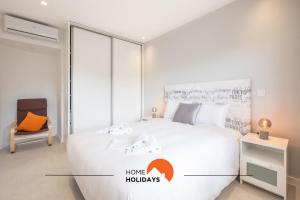 una camera da letto con un grande letto bianco e una sedia di #079 T1 Vale Mangude by Home Holidays ad Albufeira Altre 37 foto