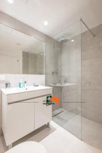 a white bathroom with a sink and a shower at #079 Center City with Pool, AC in Albufeira