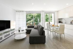 a living room with a couch and a table and a kitchen at Blissful Beach Getaway in Nazaré +16 photos