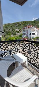 una mesa blanca y sillas en un balcón con vistas en VillaModu, en Fethiye