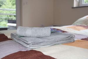 a pile of towels sitting on top of a bed at Perla Lux in Vrnjačka Banja