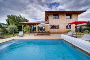 una casa con piscina frente a una casa en Villa Tchanquée, en Gujan-Mestras