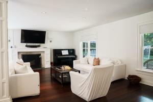 a living room with white furniture and a tv at 28 Ocean Pkwy, East Hampton NY 11937 in East Hampton