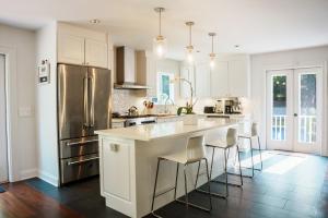 a kitchen with white cabinets and a stainless steel refrigerator at 28 Ocean Pkwy, East Hampton NY 11937 in East Hampton