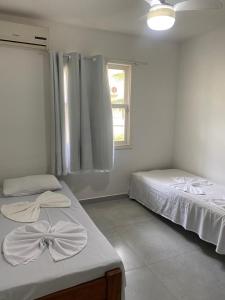 a bedroom with two beds and a window at Condomínio Golden Vilage Taperapuã in Porto Seguro