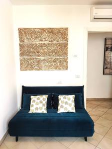 um sofá azul com duas almofadas num quarto em Il Melograno Apartment (Centro Storico Prato) em Prato