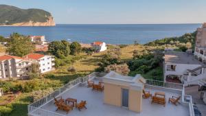 a balcony with tables and chairs and the ocean at Apartments Bonazza in Petrovac na Moru