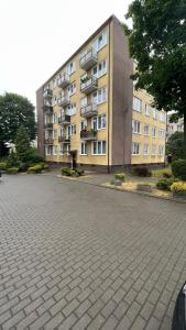 um grande edifício de apartamentos em frente a um parque de estacionamento em MŁAWSKA 33 em Rypin