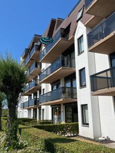 a building with a woman walking in front of it at Studio Blanchard in Koksijde +2 photos