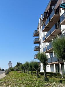 a building with a row of trees in front of it at Studio Blanchard in Koksijde