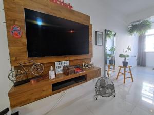 sala de estar con TV grande en la pared en Quarto privativo no melhor de Botafogo com Anfitriã - home with host en Río de Janeiro