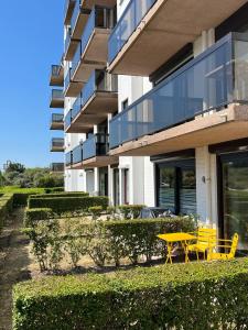 a yellow table and chairs in front of a building at Studio Blanchard in Koksijde