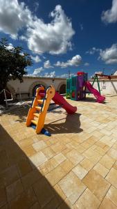 a playground with a slide and a play set at Quei Trulli Divini in Martina Franca
