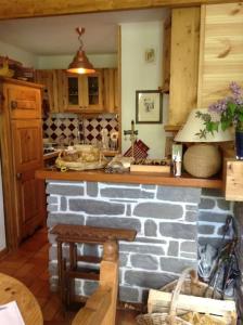 eine Küche mit einer Backsteintheke und einem Tisch in der Unterkunft Chalet en bois à la Foux d'Allos in Allos