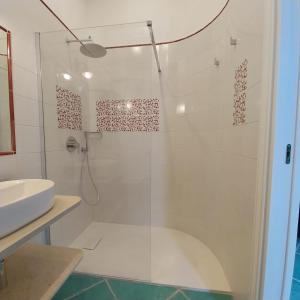 a bathroom with a glass shower with a sink at Villa del Sole in Capri