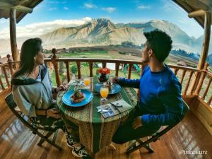 a man and woman sitting at a table on a balcony at Inkasaire Boutique Lodge in Urubamba
