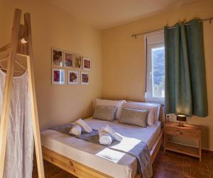 a bedroom with a bed with white pillows and a window at Primavera Suite in Stalís