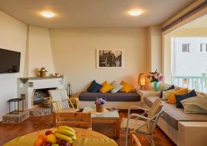 a living room with a couch and a table at Primavera Suite in Stalís