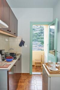 a kitchen with a sink and a counter with a window at Primavera Suite in Stalís