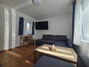 uma sala de estar com um sofá azul e uma mesa em Apartmány Modrý deň em Bojnice