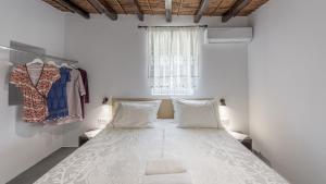 - une chambre blanche avec un lit et une fenêtre dans l'établissement Milos Bay View, à Zefiría