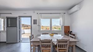 cocina y comedor con mesa y sillas en Milos Bay View, en Zefiría