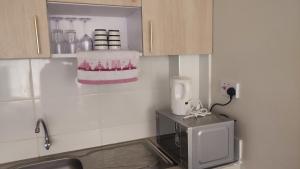 a kitchen with a sink and a microwave at Classy Spacious Studio - Waiyaki Way 