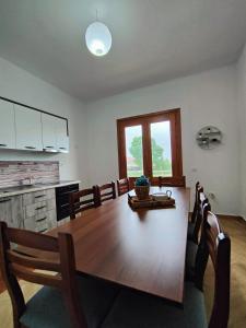 una sala da pranzo con tavolo e una cucina di Apollonia Apartment a Fier