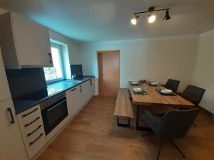 eine Küche mit einem Holztisch und einem Esszimmer in der Unterkunft Ferienwohnung Kreiller in Johanniskirchen