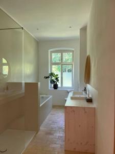 a bathroom with a sink and a tub and a window at Idyllisches Appartement nahe Ostsee und Schlei in Rabenkirchen-Faulück